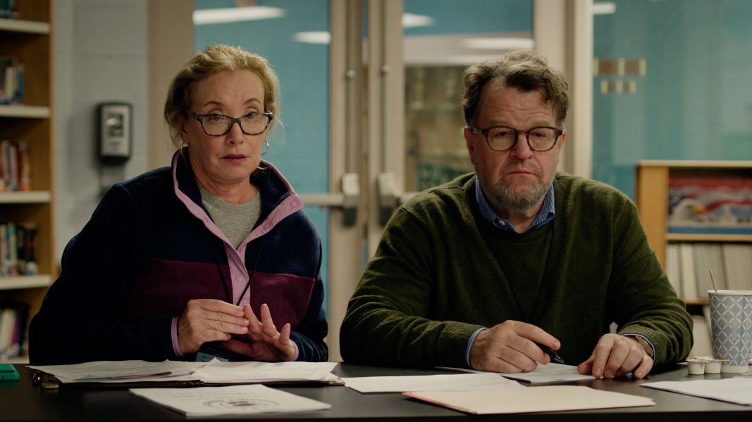 A woman and a man wearing glasses sit at a table covered with papers in a library or office, both looking ahead with serious expressions—an atmosphere reminiscent of a Sundance Film Festival or ICA Boston discussion.