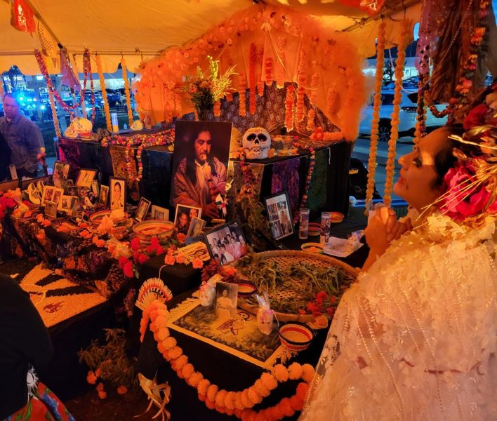 Decorated day of the dead altars with a woman in ceremonial costume