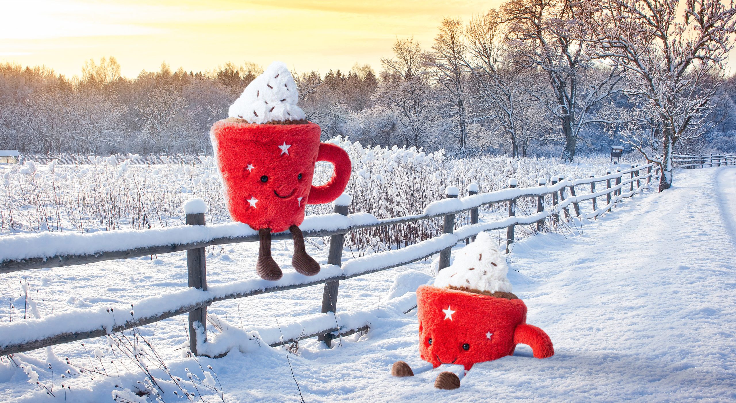 Red Jellycat mug plushies sitting in a snowy scene