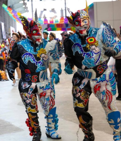 people stand in colorful armor-like costumes at a celebration
