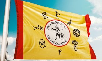 a yellow flag with a red border that reads Higuayagua: Taíno of the Caribbean