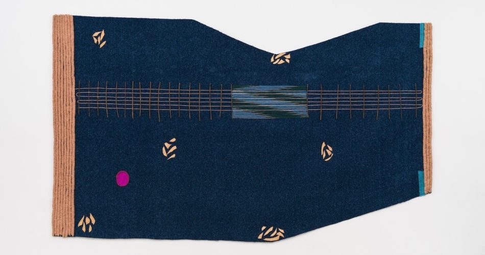 An irregularly shaped wall textile in deep blue with pale orange abstract details and trim.