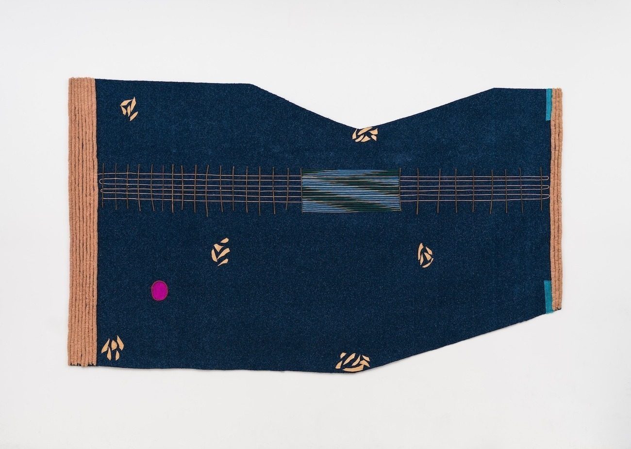 An irregularly shaped wall textile in deep blue with pale orange abstract details and trim.