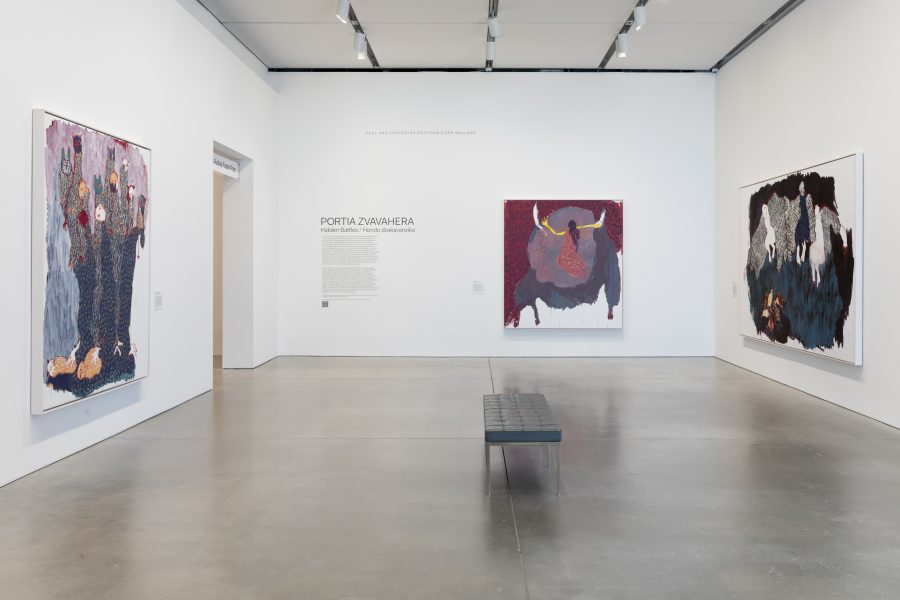 A gallery with white walls at ICA/Boston displays three large, colorful abstract paintings by Portia Zvavahera. A black bench sits in the center of the polished concrete floor. An exhibition title and wall text appear ahead.
