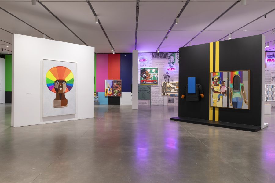 A gallery with colorful paintings and digital artworks on white and black walls, featuring bright paintings, wallpapered walls, and neon lighting on one side