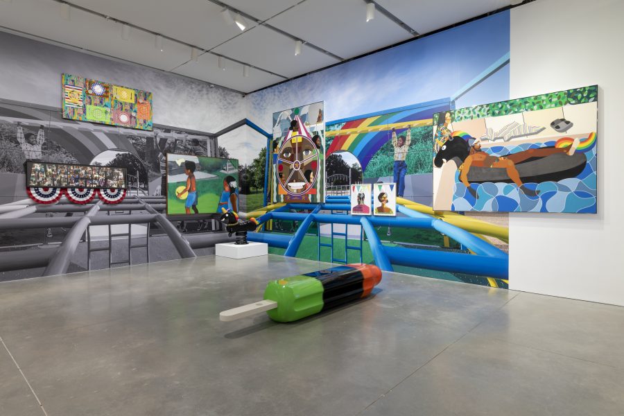 A gallery features vibrant paintings and murals with colorful, dynamic scenes and people, plus a large popsicle sculpture on concrete flooring