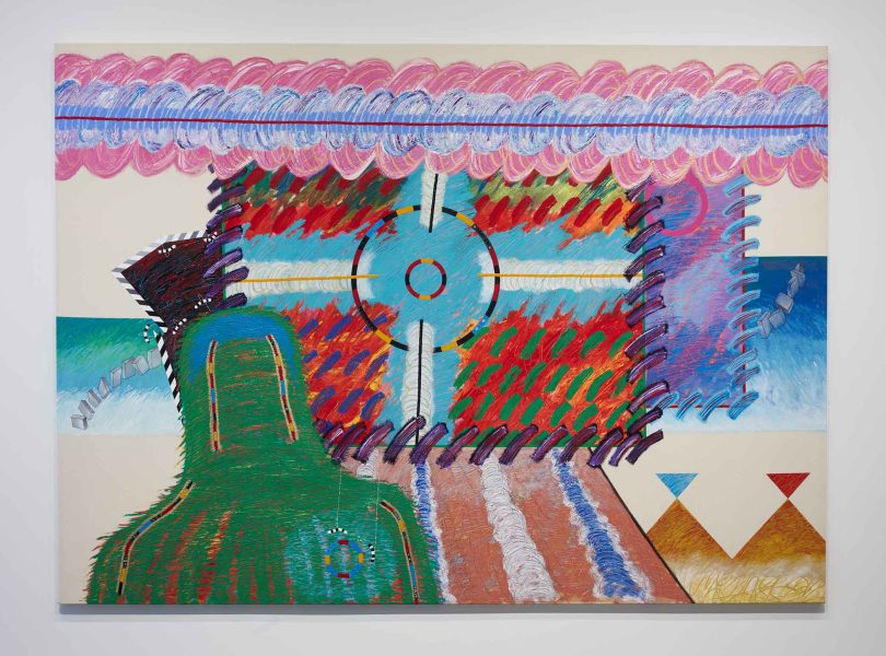 Colorful abstract painting with bold, textured brushstrokes. Features geometric shapes, zigzag and circular patterns, and vibrant hues of red, green, blue, and purple against a cream background.