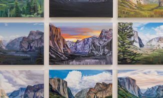 Nine oil paintings, reminiscent of Cynthia Daignault’s style showcased at ICA Boston, depict scenic mountain landscapes with dramatic clouds, lush greenery, rock formations, and a colorful sunset, all arranged in a three-by-three grid on a white wall.