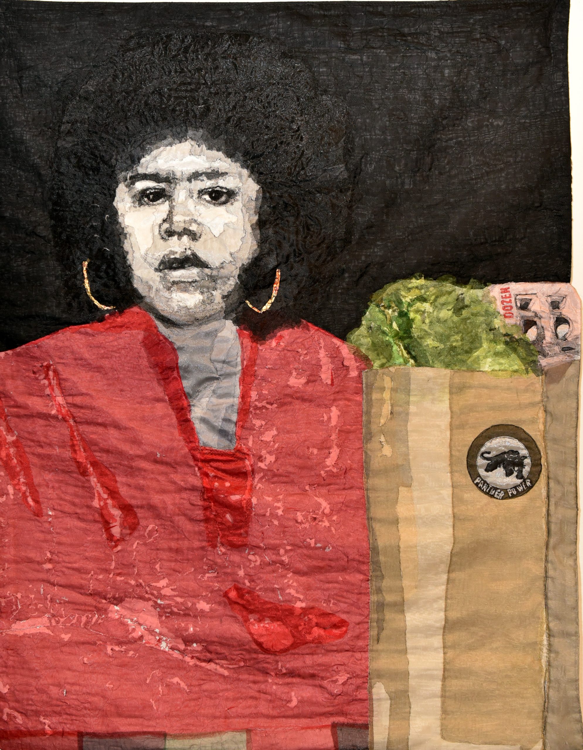 A textile artwork depicts a woman with an afro, gold hoop earrings, and a red top, holding a brown grocery bag containing lettuce and currency, set against a dark background.