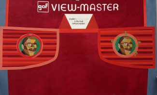 An illustration of a red View-Master toy with two eyepieces, each showing a stylized face. Above, the text reads gaf VIEW-MASTER. A white label in the center says, Double Consciousness is the dual self-perception.