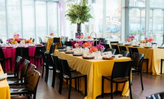 Tables set with decor and vibrant table clothes fill the Lobby of the ICA