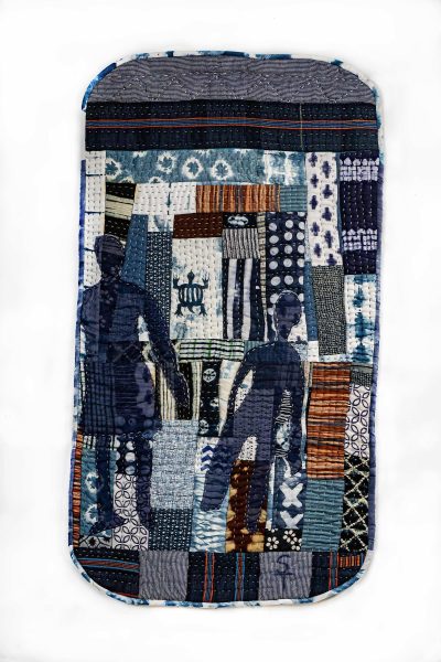 A textile artwork featuring a colorful patchwork background with blue, orange, and patterned fabric pieces, overlaid with two dark blue silhouetted human figures standing and walking.