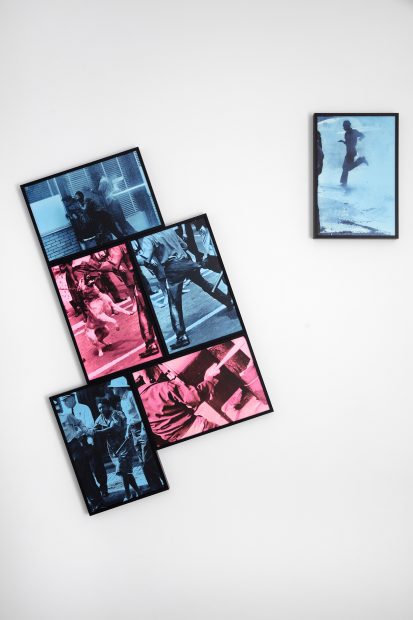 Four framed prints in blue and pink tones featuring people in motion are arranged in a staggered cluster on a white wall, with a fifth smaller print of a running figure hung separately to the right.