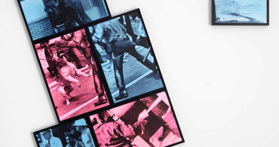 Four framed prints in blue and pink tones featuring people in motion are arranged in a staggered cluster on a white wall, with a fifth smaller print of a running figure hung separately to the right.