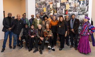Current and former AAMARP artists posing for a group photo in the Say It Loud: AAMARP, 1977 to Now gallery space.