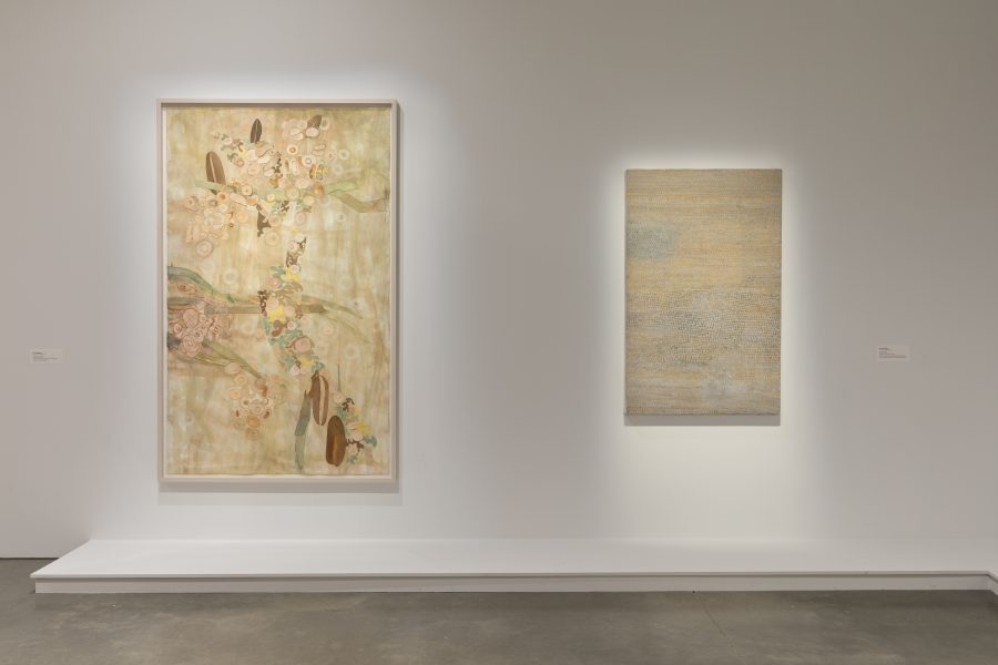 Two abstract paintings hang on a white gallery wall.