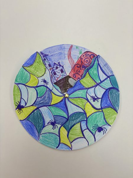A circular drawing with a colorful spiderweb pattern, featuring small spiders and a glimpse of a castle tower and red patterned shape in the center.